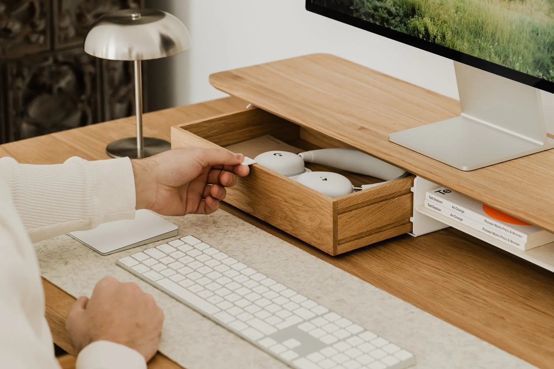 Hand opening a drawer in an oak Deskshelf Pro