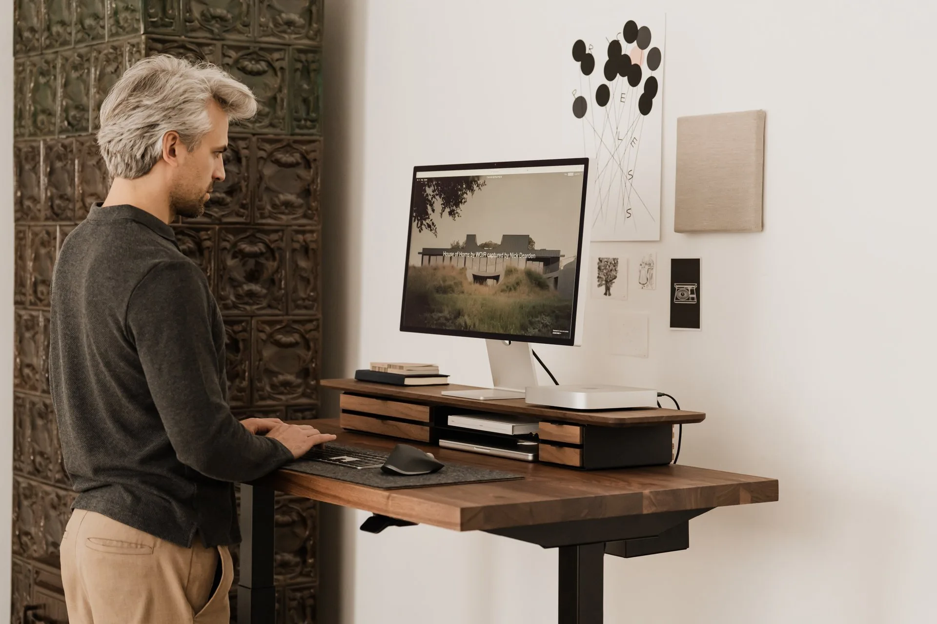 Man standing at a desk with a walnut Deskshelf Pro