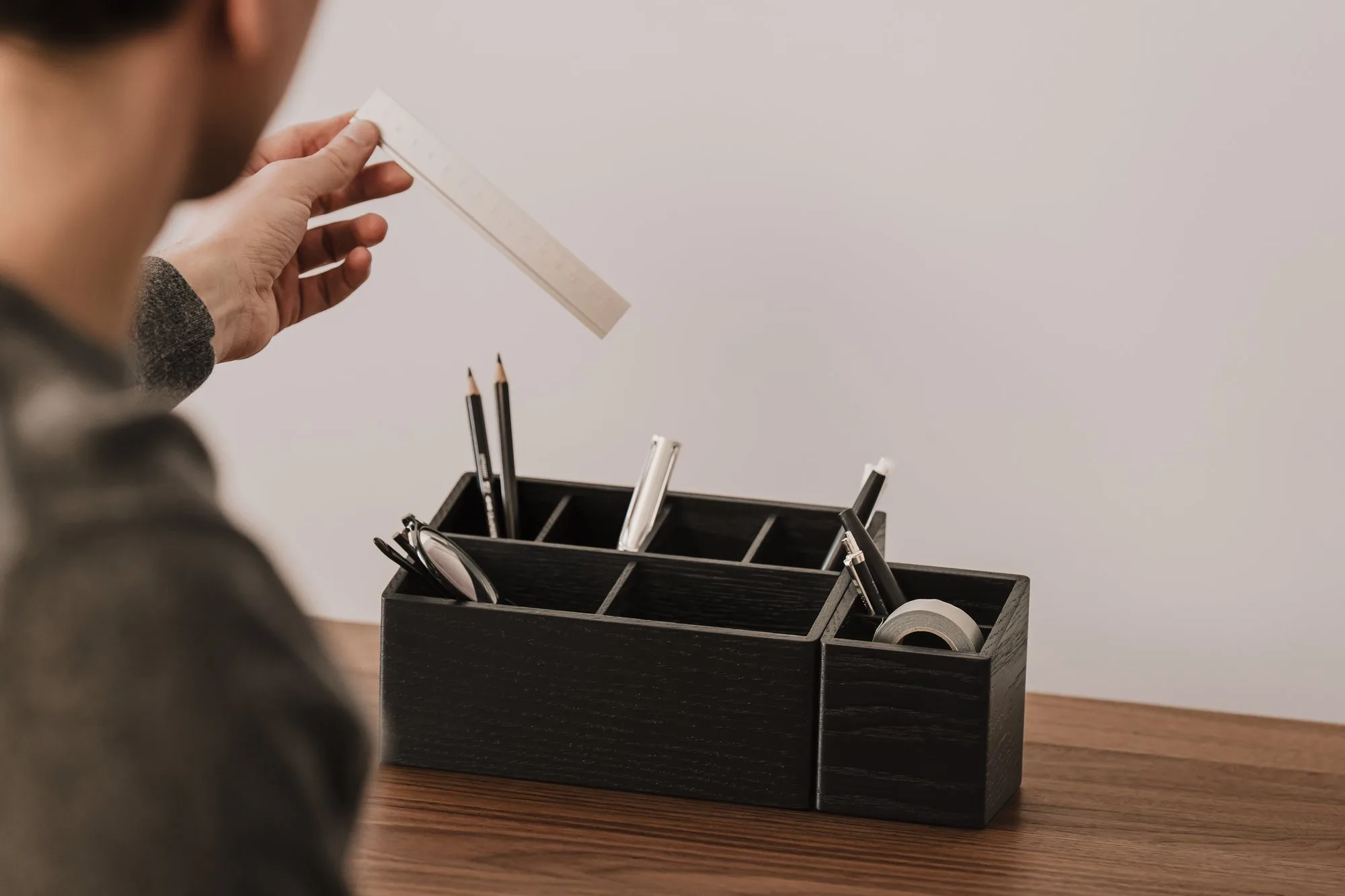 Hand placing a ruler into a black organiser