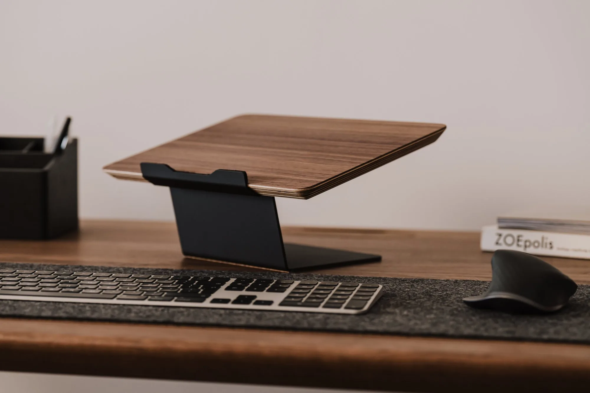 Empty walnut riser on a desk behind a keyboard
