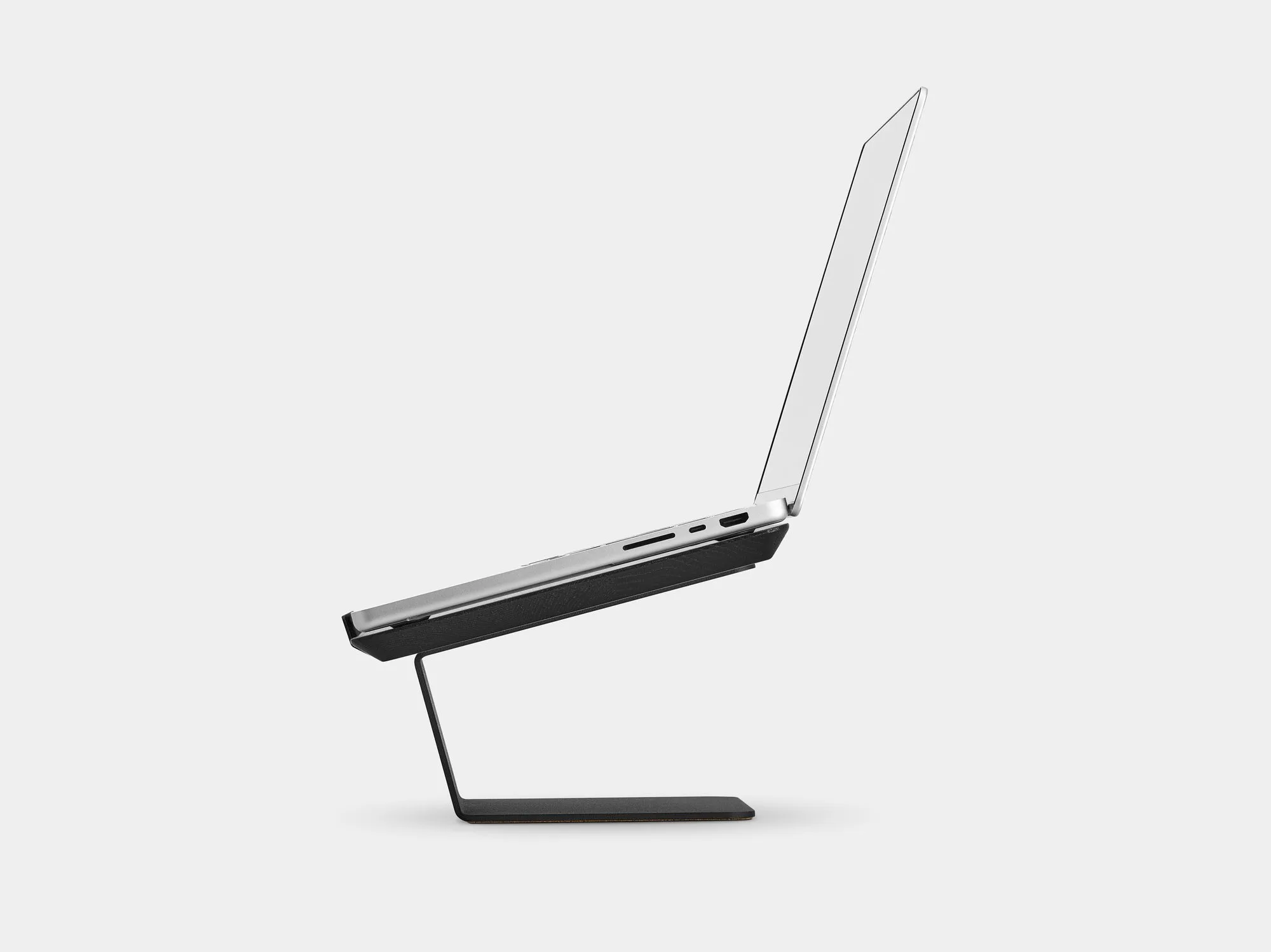 Laptop on a black riser, side view on a grey background