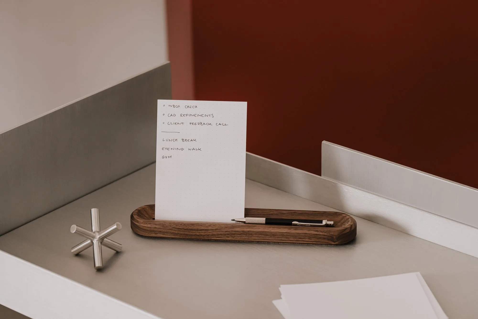 Walnut card holder with a card on a grey metal shelf